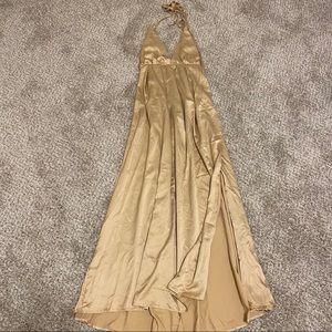 Long gold backless dress with side slit.
